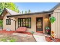 Inviting front porch with a swing, colorful plants, and a decorative welcome bear at 11094 Thomas Dr, Conifer, CO 80433