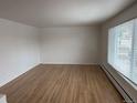 Spacious living room with hardwood floors and a large window for natural light at 1530 Whippoorwill Dr, Lakewood, CO 80215