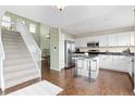 Modern kitchen with stainless steel appliances, a center island with bar stools, and white cabinetry at 9719 Burberry Way, Highlands Ranch, CO 80129