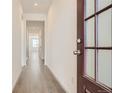 Bright hallway with wood floors, neutral walls, and natural light streaming through the entrance door at 13826 Honey Hush Trl, Parker, CO 80134