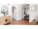 Bright hallway with hardwood floors, decorative mirror, and access to dining area with modern chandelier at 3519 Newton St, Denver, CO 80211