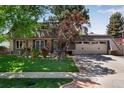 Inviting home exterior with an attached garage and a well-kept front lawn and landscaping at 8427 Chase Dr, Arvada, CO 80003