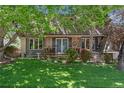 Charming exterior showcasing a manicured lawn, landscaped garden beds and covered front porch at 8427 Chase Dr, Arvada, CO 80003