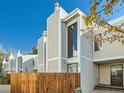 Modern townhome exterior with unique architectural design, fencing, and a well-manicured landscape at 1050 S Monaco Pkwy # 106, Denver, CO 80224