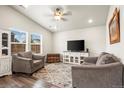 Cozy living room with vaulted ceilings, recessed lights, and wood-look floors with large windows at 653 S Hoover Ave, Fort Lupton, CO 80621