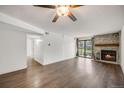 Spacious living room with hardwood floors and a stone fireplace leading to a balcony with bright natural light at 401 S Kalispell Way # 206, Aurora, CO 80017