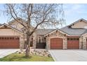 Charming townhome featuring stone accents, a two-car garage, and a well-manicured front yard at 2714 Calmante Pl, Superior, CO 80027