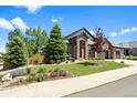 Beautifully landscaped front yard and brick exterior creates great curb appeal at 7472 Iridium Way, Castle Rock, CO 80108