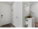 Bright entryway with white walls, wood floor, decorative mirror, and doors at 5121 N Yampa St, Denver, CO 80249