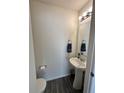 Cozy powder room featuring a pedestal sink, mirror, and toilet at 5121 N Yampa St, Denver, CO 80249