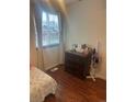 Cozy bedroom with wood floors, a dresser, and a bright window at 8452 Everett Way # C, Arvada, CO 80005