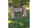 Timber Cove neighborhood sign with stone pillars and lush green lawn at 8452 Everett Way # C, Arvada, CO 80005