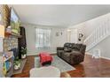 Cozy living room with hardwood floors, fireplace, stairs, and ample natural light at 8452 Everett Way # C, Arvada, CO 80005