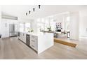 Open-concept kitchen and living area with modern appliances, large island, and hardwood floors at 3530 Fenton St, Wheat Ridge, CO 80212