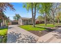 Charming single-story home with landscaped front yard, detached garage, and inviting curb appeal at 949 Pontiac St, Denver, CO 80220