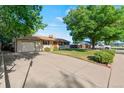 Lovely ranch-style home featuring a long driveway and well-kept lawn in a quiet neighborhood with mature trees at 7310 Granada Rd, Denver, CO 80221