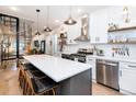 Modern kitchen boasts stainless steel appliances, white cabinets, quartz counters, and a large center island at 3443 Lawrence St, Denver, CO 80205