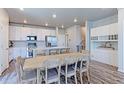 Bright kitchen featuring stainless steel appliances, a kitchen island and adjacent dining area at 5156 Bittercress Rd, Brighton, CO 80640