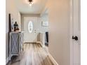 Bright foyer with light hardwood floors, decorative front door, and stylish cabinet at 6342 W Fremont Dr, Littleton, CO 80128