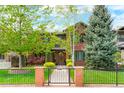 Charming red brick home with manicured lawn and garden beds, partially obscured by mature trees at 2153 S Columbine St, Denver, CO 80210