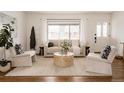 Bright living room with large windows, modern furniture, neutral tones, and hardwood floors, offering a cozy atmosphere at 1475 S Urban Way, Lakewood, CO 80228