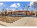 Lovely brick home with a long driveway, showcasing ample parking space and detached garage at 1275 Otis St, Lakewood, CO 80214