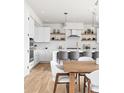 Bright, modern kitchen with white cabinets, stainless steel appliances, and a kitchen island with seating at 1330 W 35Th Ave, Denver, CO 80211