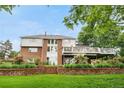 Charming home featuring a large deck, brick accents, lush landscaping, and a well-maintained lawn at 7330 Routt St, Arvada, CO 80005