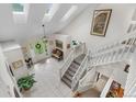 Bright foyer with skylights, tile flooring, staircase, and a decorative bench for a welcoming entrance at 7330 Routt St, Arvada, CO 80005