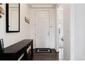 Bright entryway featuring a white door, coat rack, wood flooring and a view into the house at 11823 Barrentine Loop, Parker, CO 80138