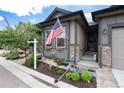 Close up of the home's entrance and landscaping, highlighting the American flag and stone accents at 11823 Barrentine Loop, Parker, CO 80138