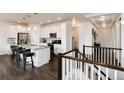 Open kitchen with white cabinetry, stainless steel appliances, and a center island with bar seating at 11823 Barrentine Loop, Parker, CO 80138