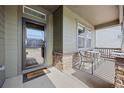 Inviting front porch with seating area, stone accents, and a clear view of the neighborhood at 525 Grenville Cir, Erie, CO 80516