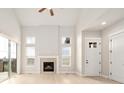 Light and airy living room showcasing a fireplace, a ceiling fan and access to the outdoor patio at 2611 Prairie Flax St, Berthoud, CO 80513