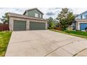 Attached three-car garage with a concrete driveway provides ample parking, set against a green-sodded lawn at 21396 E Prentice Ln, Centennial, CO 80015