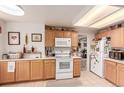 Bright kitchen features light-wood cabinets, white appliances, and tiled flooring, perfect for culinary adventures at 21396 E Prentice Ln, Centennial, CO 80015