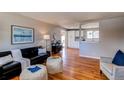 Open living room with hardwood floors, a modern sofa and kitchen view at 867 S Everett St, Lakewood, CO 80226