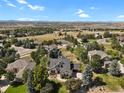 Stunning aerial view of the house nestled in a lush green neighborhood with mountain views in the distance at 5421 Potentilla Ct, Parker, CO 80134