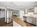 Functional kitchen with stainless steel appliances, wood floors, a central island, and ample counter space at 8727 E Girard Ave, Denver, CO 80231