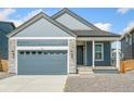 Inviting home exterior with a gray garage door and stone siding accents at 9343 Biscay St, Commerce City, CO 80022