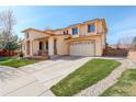 Exterior view showcasing a spacious driveway, attached two-car garage, and a well-maintained lawn at 16650 E 107Th Ct, Commerce City, CO 80022