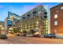 Exterior of building showing balconies, large windows, and street view with parked cars under a twilight sky at 1890 Wynkoop St # 806, Denver, CO 80202