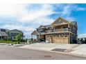 Two-story home featuring a three-car garage, balcony, and low maintenance front yard at 20503 E 50Th Pl, Denver, CO 80249