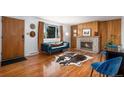 Inviting living room featuring a cozy fireplace, stylish hardwood floors, and a comfortable blue sofa at 8209 Benton Way, Arvada, CO 80003