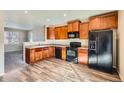 Modern kitchen with wood cabinets and black appliances at 164 Bristlecone St, Brighton, CO 80601