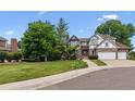Charming two-story home with brick and neutral trim and a three-car garage at 9117 Buck Hill Dr, Highlands Ranch, CO 80126