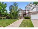 Well-manicured front yard leads to this charming two-story home with brick and neutral trim at 9117 Buck Hill Dr, Highlands Ranch, CO 80126