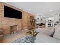 Cozy living room features a brick accent wall, fireplace, and modern furnishings at 3005 California St, Denver, CO 80205