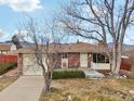 Brick ranch home with attached garage and mature trees at 4611 S Queen St, Littleton, CO 80127