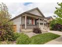 Attractive home with a covered front porch, manicured lawn, and easy access to the attached garage at 9643 Birch Ln, Thornton, CO 80229